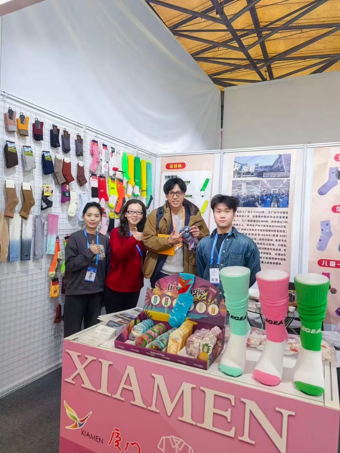 ANV Socks team meeting international buyers at the East China Fair booth, with sport socks and gift-pack displays