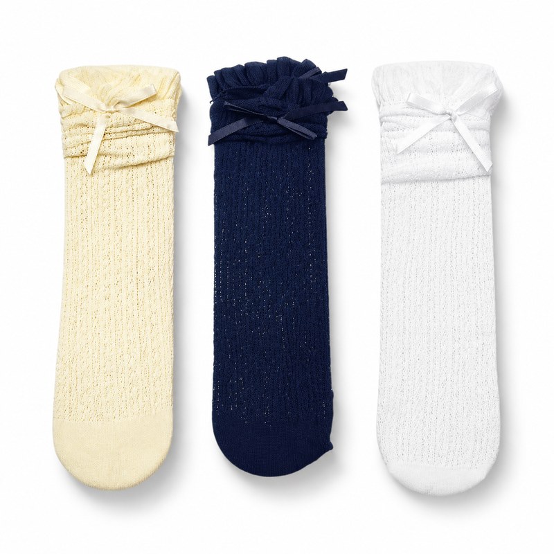 Lace Ribbon Trio by ANV Socks — 100% Nylon. Set of three lace knee-high socks in cream, navy, and white with ribbon bow decorations and ruffle cuffs. Versatile color palette for retail multi-packs and gift sets.